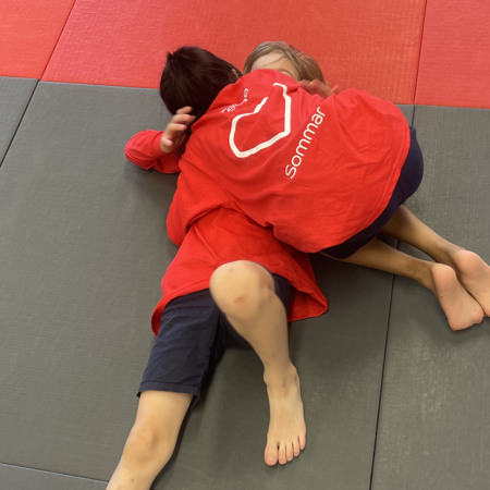 Två barn brottas på judo lägret