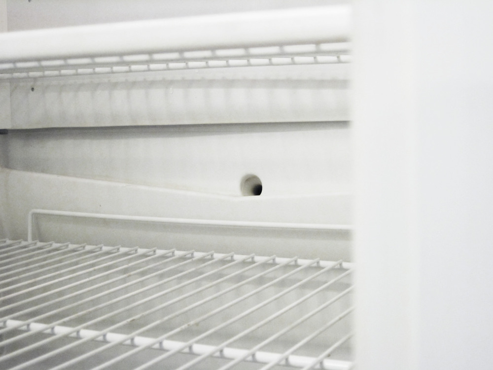 Insidan av ett kylskåp som visar avrinningshålet
