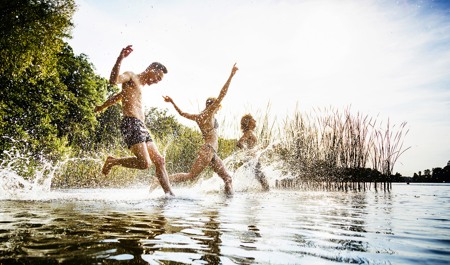 Tre personer springer ner i sjön för att bada