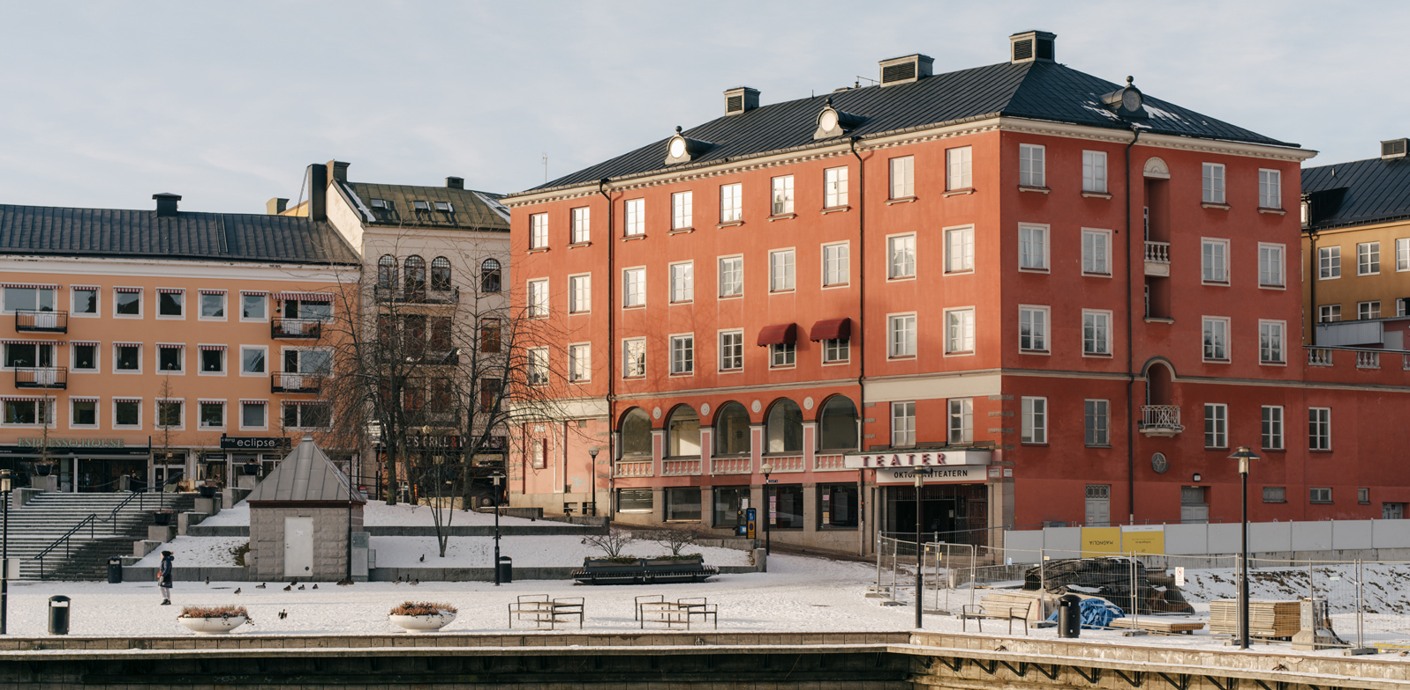 Kvarteret Castor i Södertälje, röd flervåningsbyggnad som ligger vid vattnet.