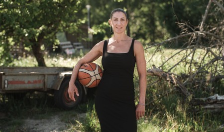 Kvinna i klänning med basketboll under armen