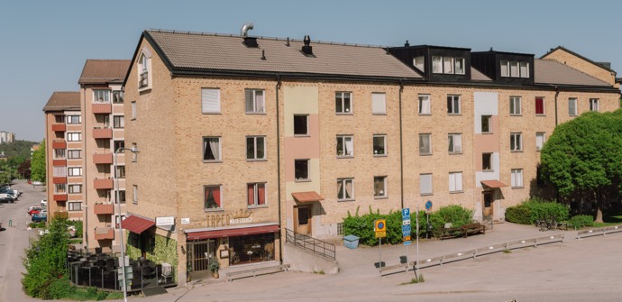 Ett hyreshus med en parkeringsplats framför sig