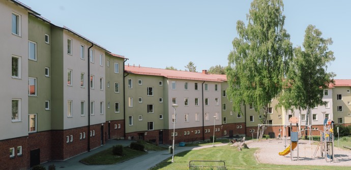 En grupp byggnader med en lekplats framför sig