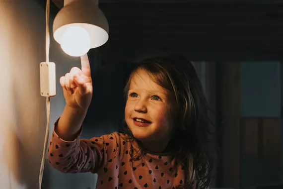 En liten flicka som håller i en lampa.
