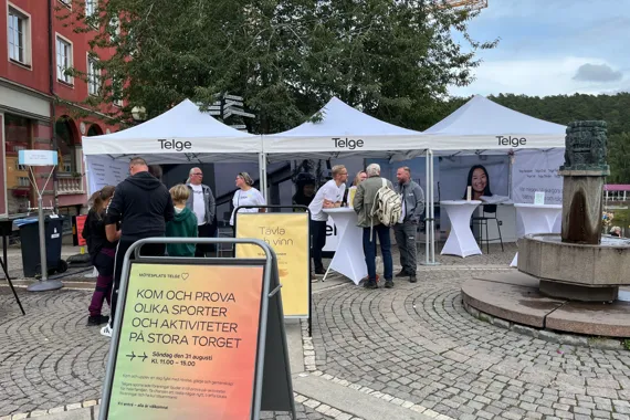 En grupp människor som står runt ett vitt tält.
