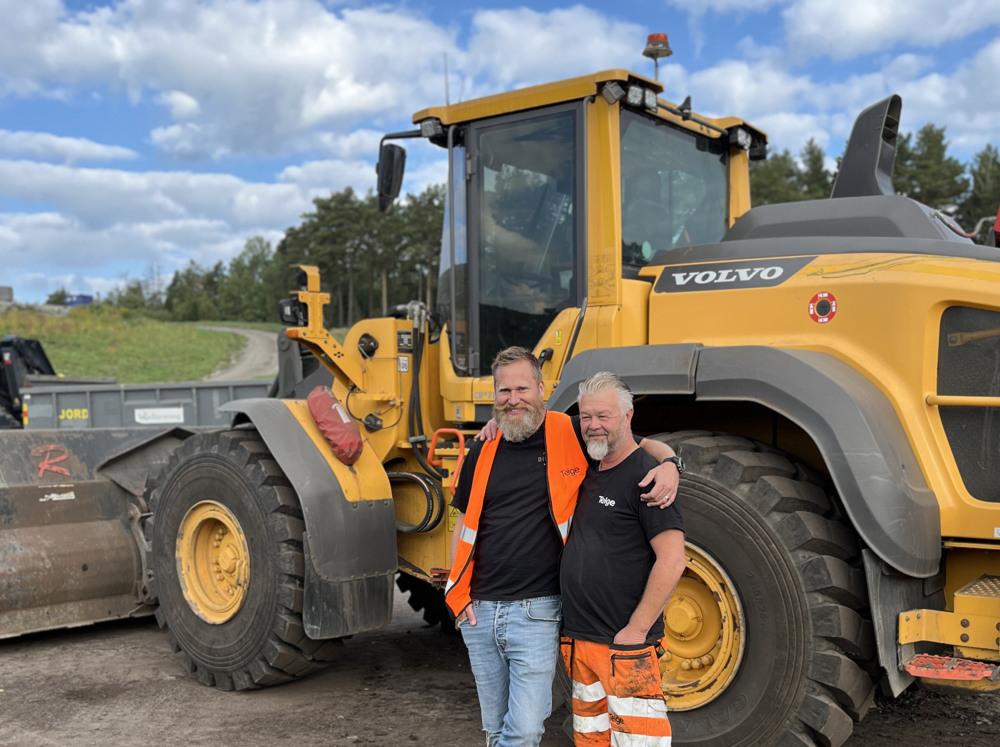 Några män som står bredvid en traktor.
