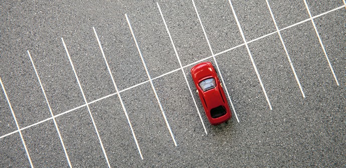 En röd bil står på en parkeringsplats