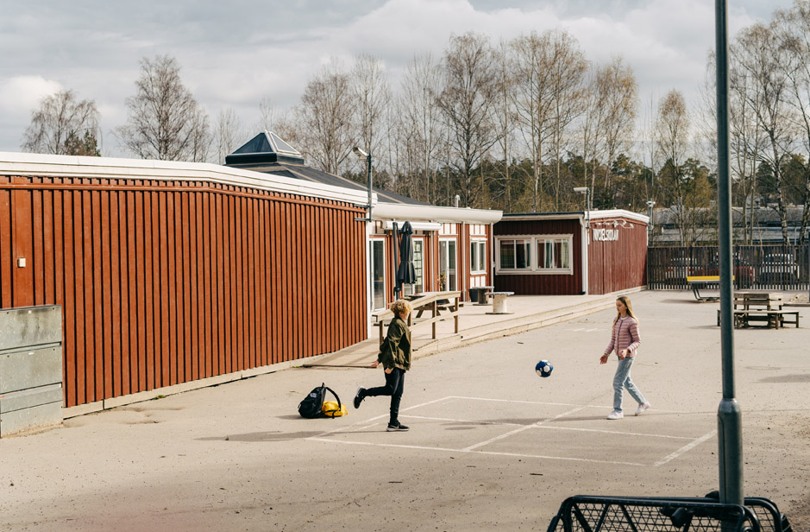 Skolbarn som leker med en boll på skolgården
