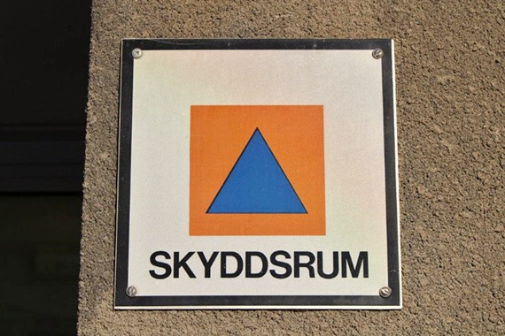 En skylt på sidan av en byggnad där det står skyddsrum.