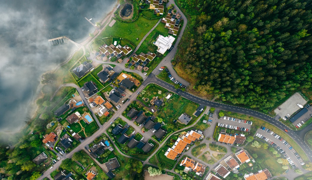 En flygbild av ett bostadsområde vid vatten. 