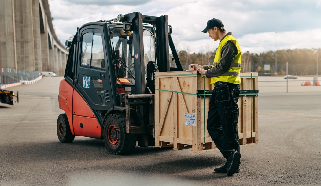 En kille i keps och varselklädsel framför en truck