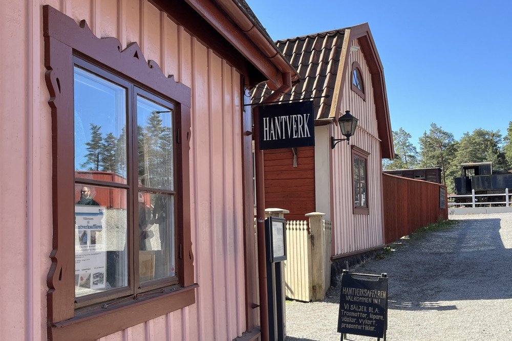 En rosa byggnad med en skylt framför sig.